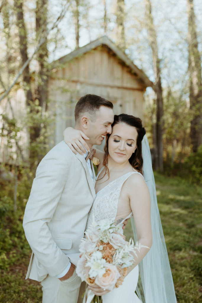 Madelyn and her fiance standing in front of a cute barn next to the bridal house at L & L Farm.