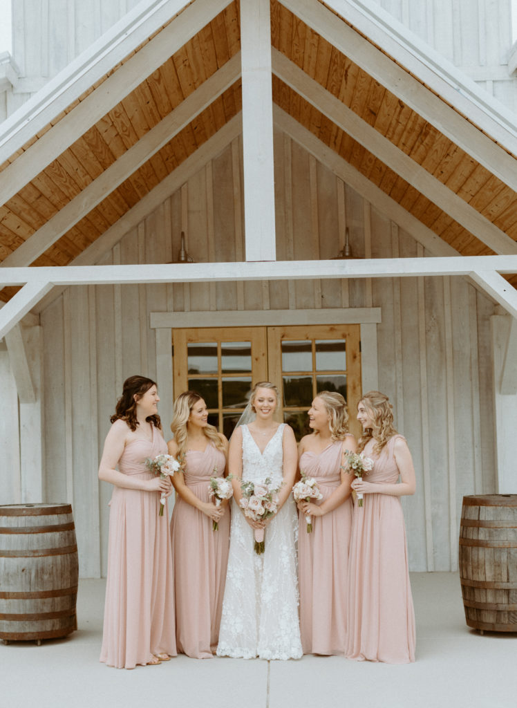 Amanda and her bridesmaids standing in front of the venue at Cranford Hollow
