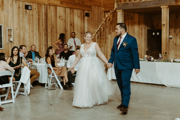 Rachel and Juan heading to do their first dance in front of family and friends. Inside the barn at firefly lane wedding venue.