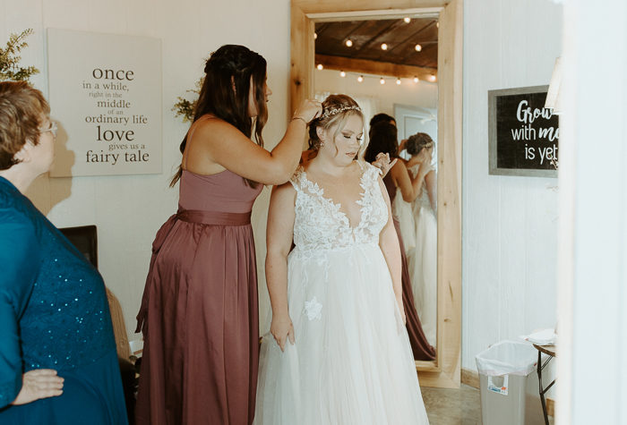 Rachels bridesmaid helping her put her veil in on her wedding day in the bridal suite at firefly lane wedding and events venue.
