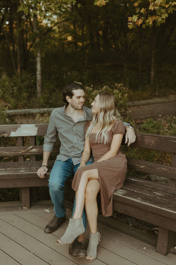 Megan and Sean snuggling close together on a bench at Radnor lake state park.