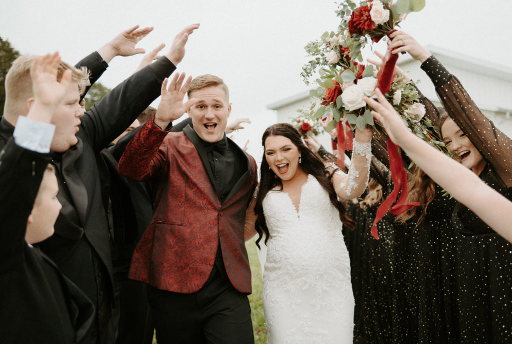 Shelby and Jacob filled with excitement as they walk through their bridal party on their wedding day. 