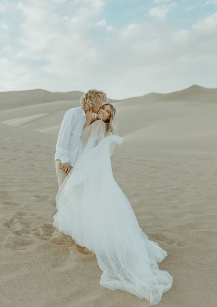 Cheeky hugs from the bride and groom during their Colorado Elopement at the Great Sand Dunes National Park. 