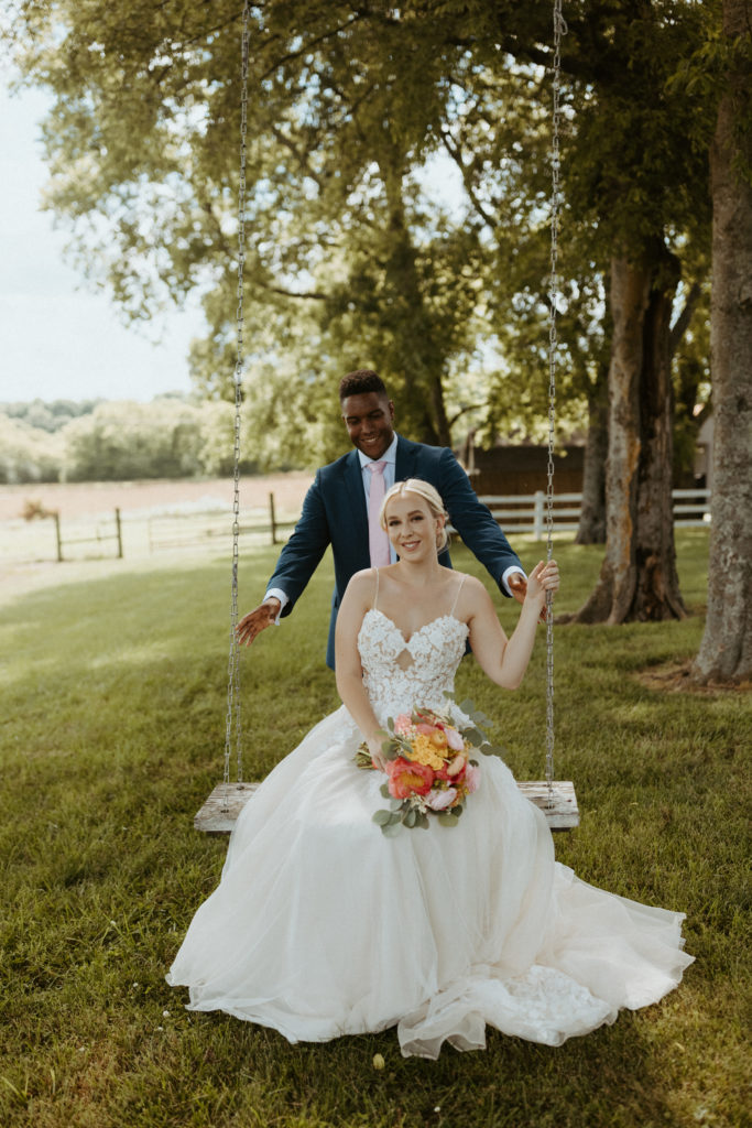 Bride and groom swinging on a swing during portraits during a styled shoot put on by a Nashville Wedding Planner.