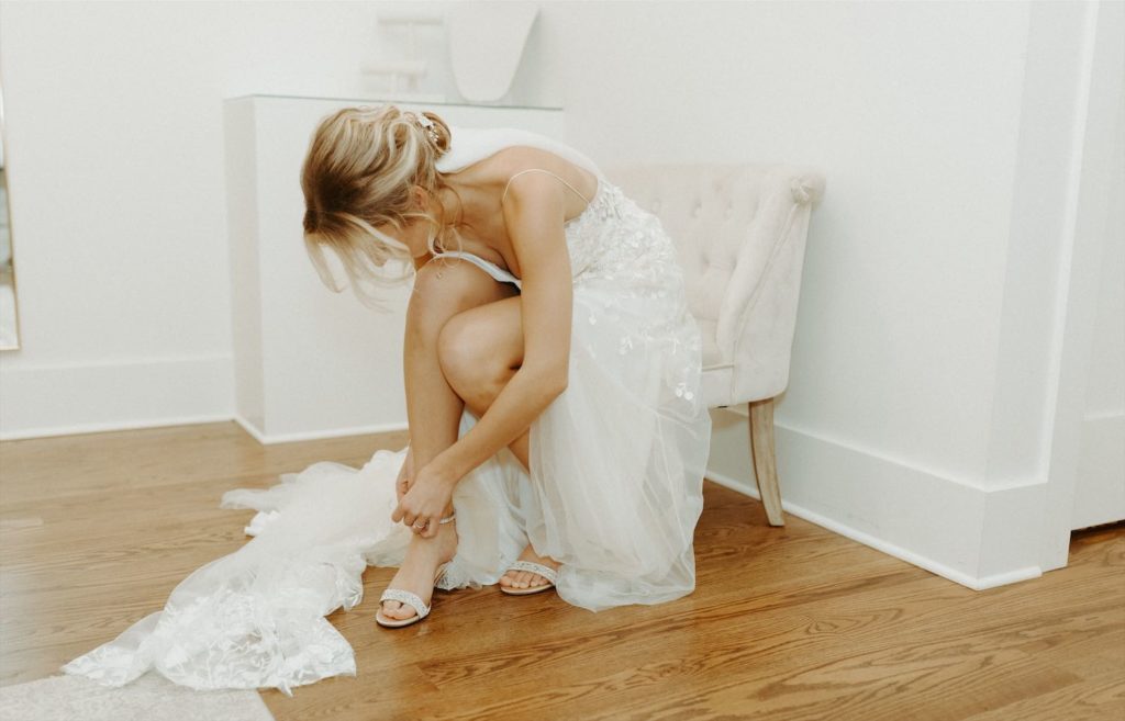 Bride putting on her heels on her wedding day at The Venue at Birchwood.