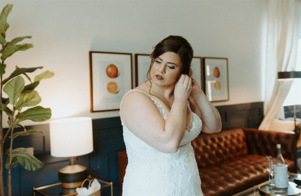 Marissa putting in hear earrings during her wedding day at Clementine Hall. 