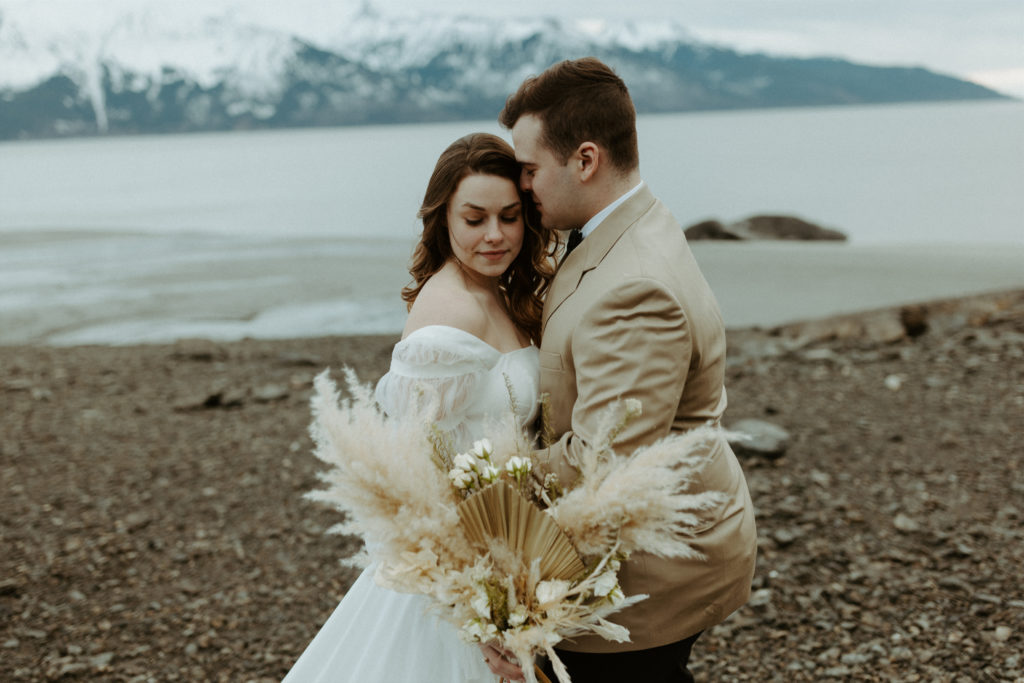 Bride and groom holding florals from their wedding in Alaska 