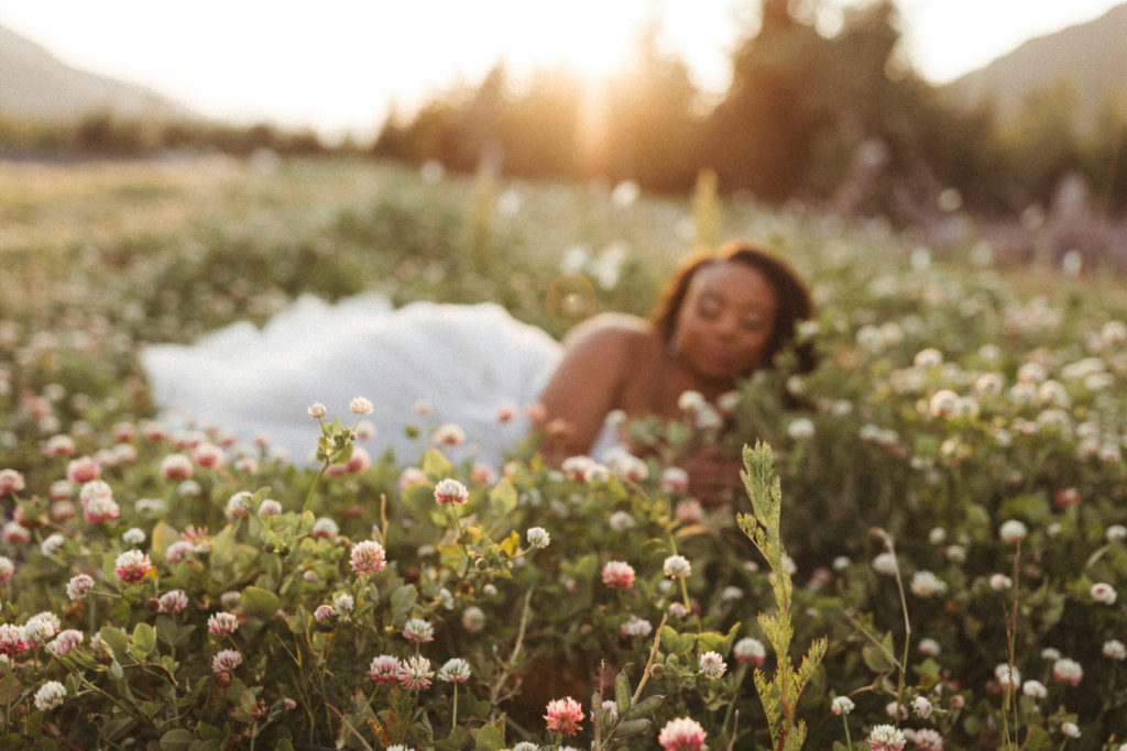 Bride laying in a field during her bridal session in Girdwood, Alaska.
