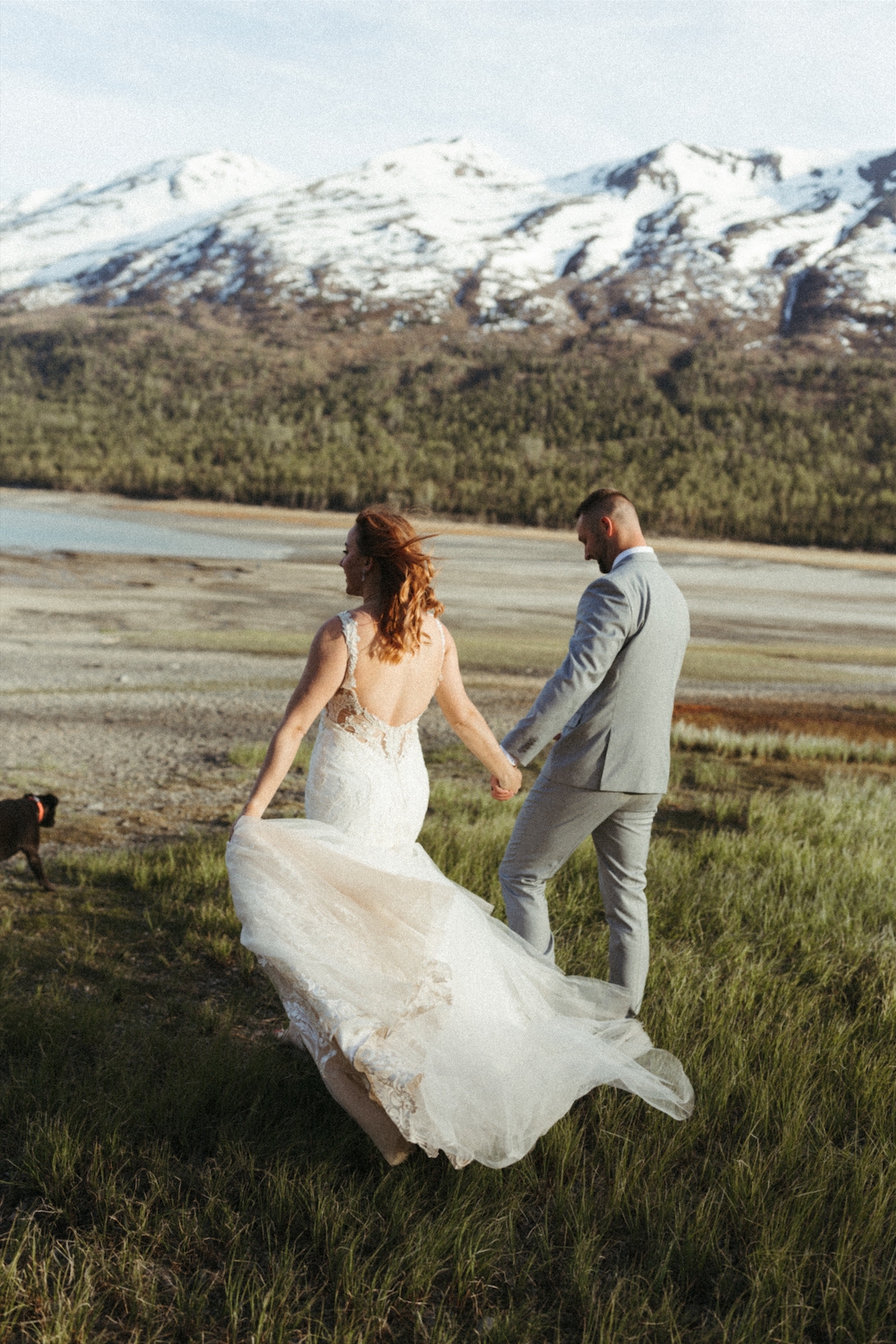 bride and groom walking toward the mountains during their wedding photoshoot