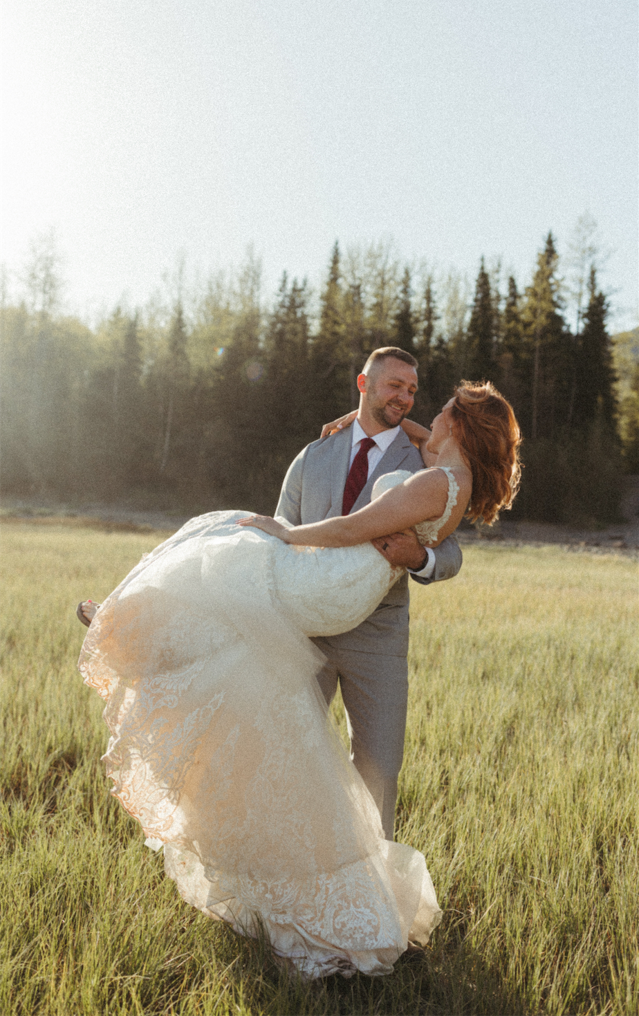 Groom carrying bride during their anniversary photos in Alaska 