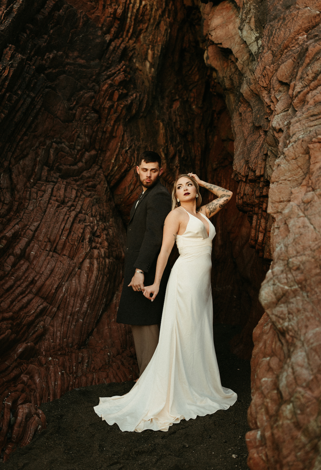 couple standing in a cave while getting married in Alaska 