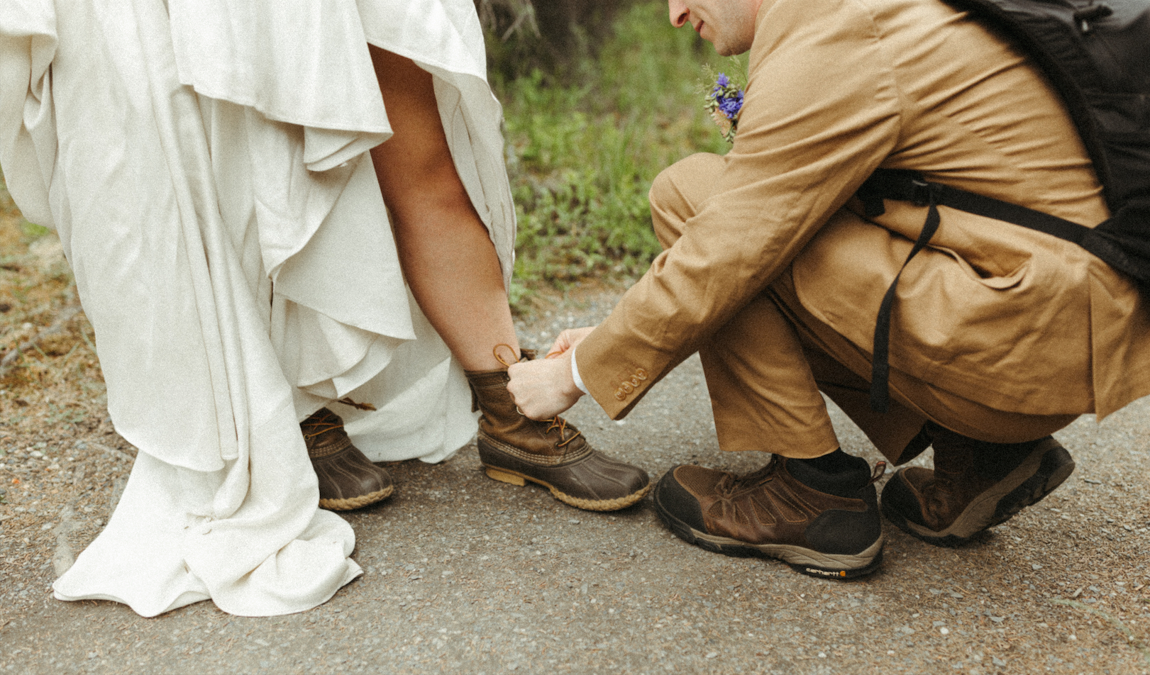 Groom tying brides shoes during an elopement in Alaska