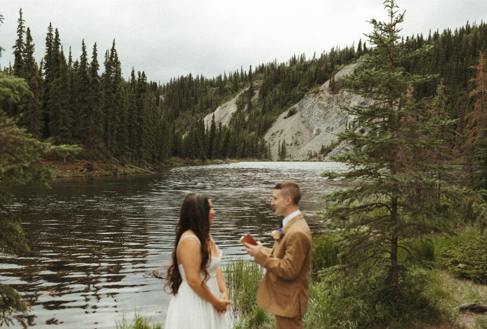 Couple reading their vows to eachother during their Alaska elopement 