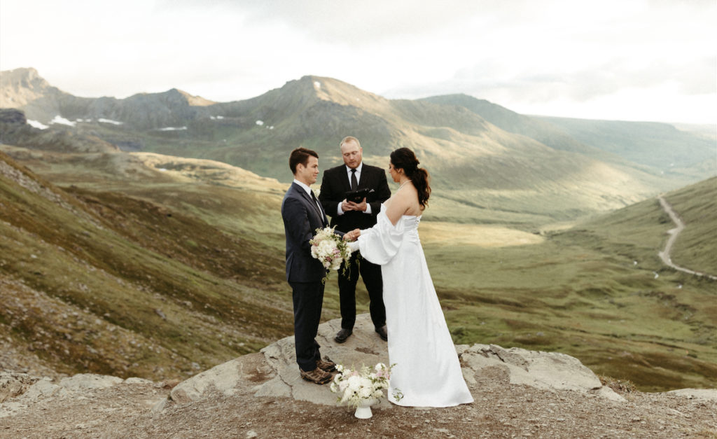 Couple standing on an overlook in Hatchers Pass a popular location in Alaska for their wedding ceremony 