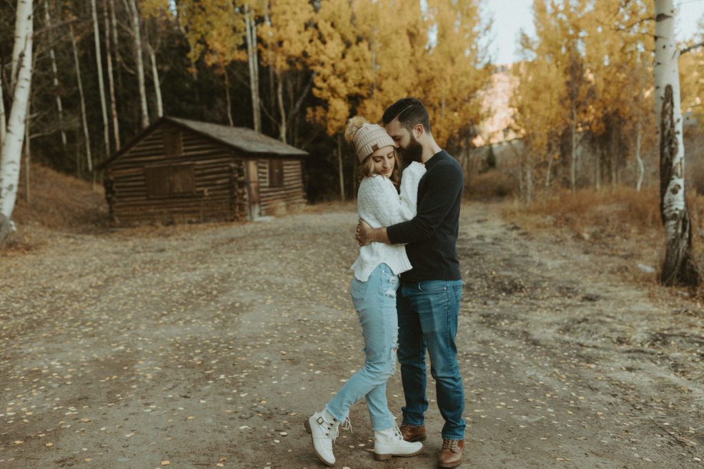 Couple standing outside their cabin during their couples photoshoot in Colorado