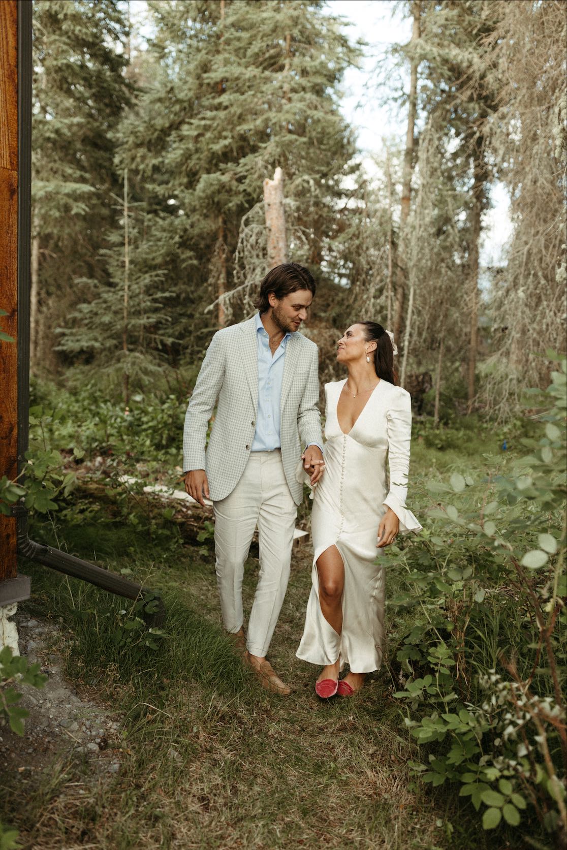 couple walking through the woods during their intimate wedding day in Kenai Alaska 
