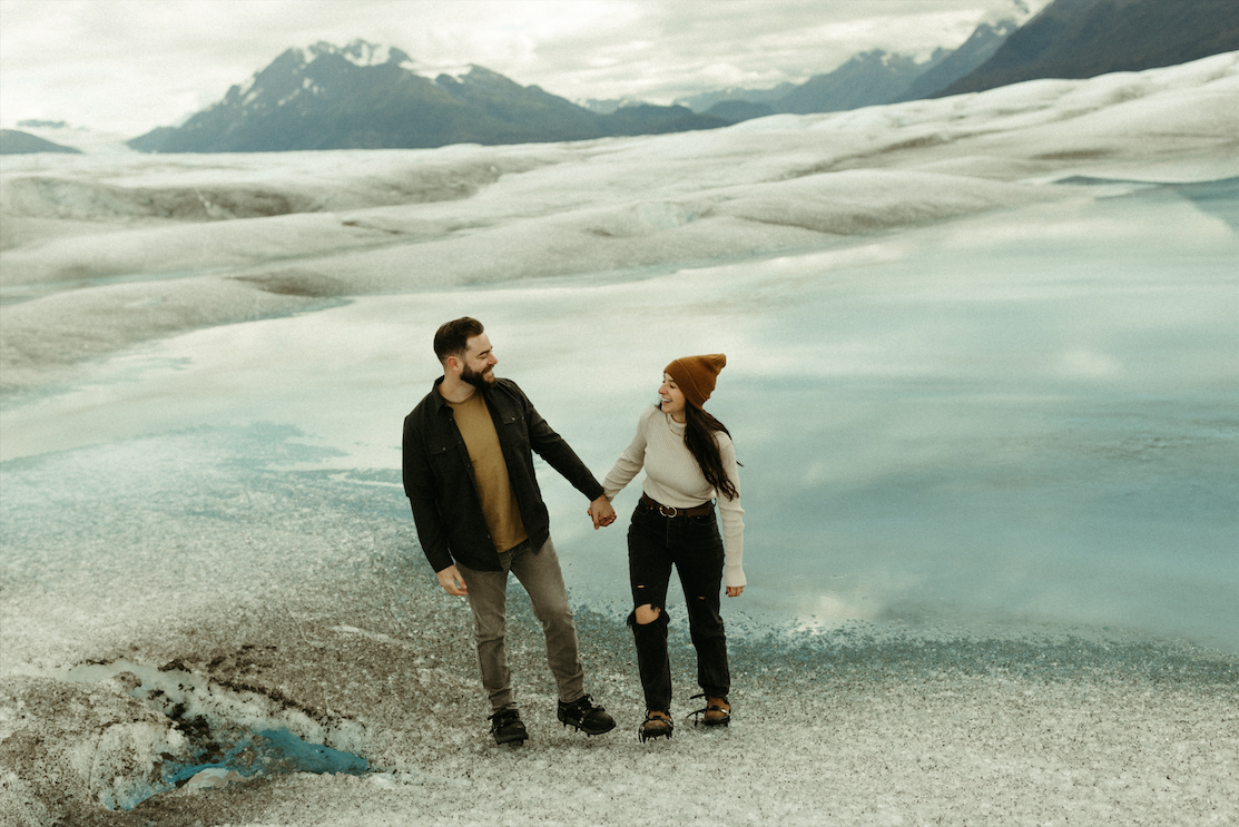 Couple walking along the ice during their Alaska helicopter tour