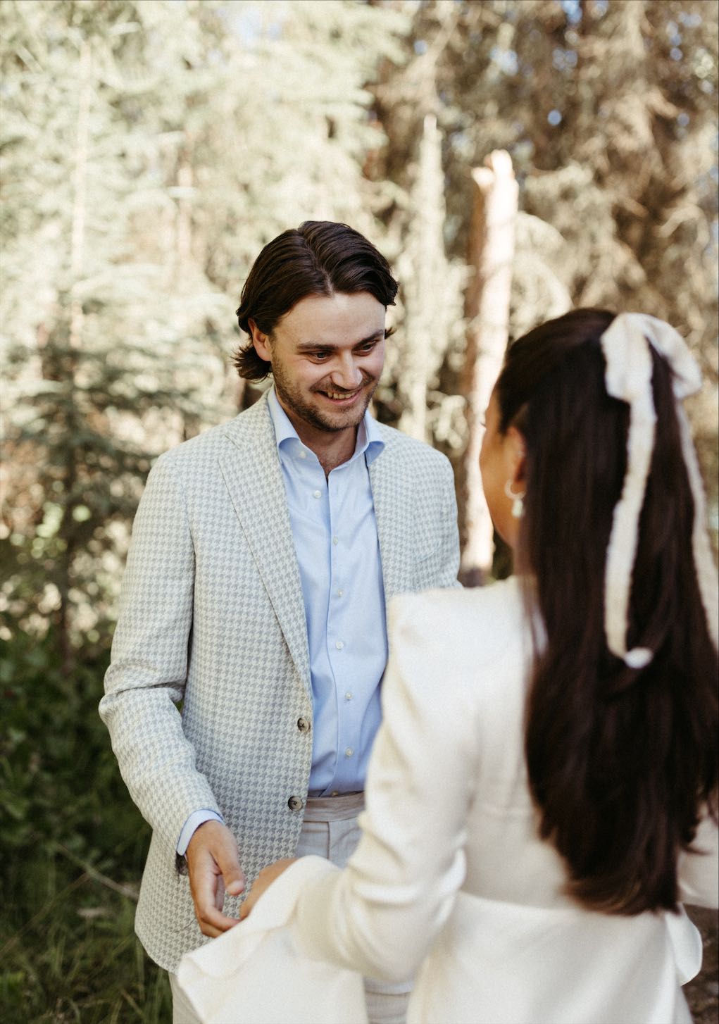 Groom smiling as he looks at his soon to be wife
