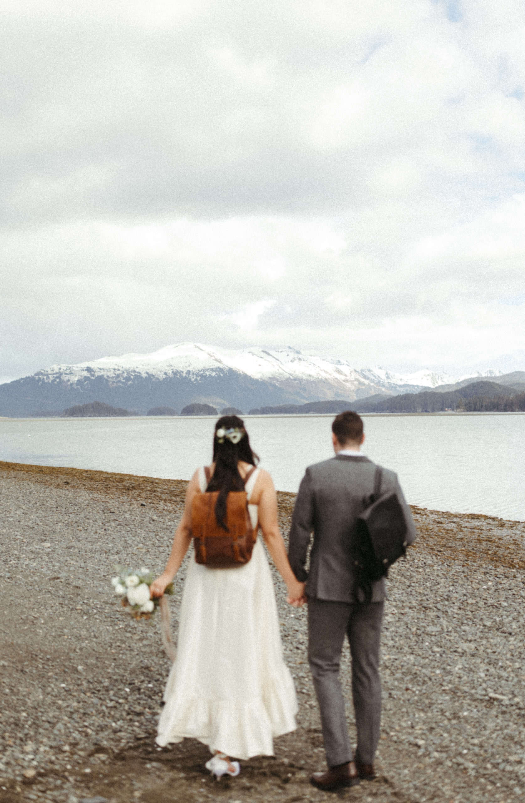 Couple walking toward the mountains during a Homer, Alaska wedding