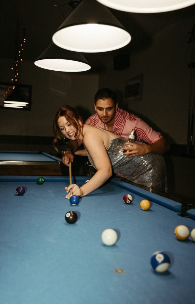 Couple playing pool during their engagement photos in Palm Springs