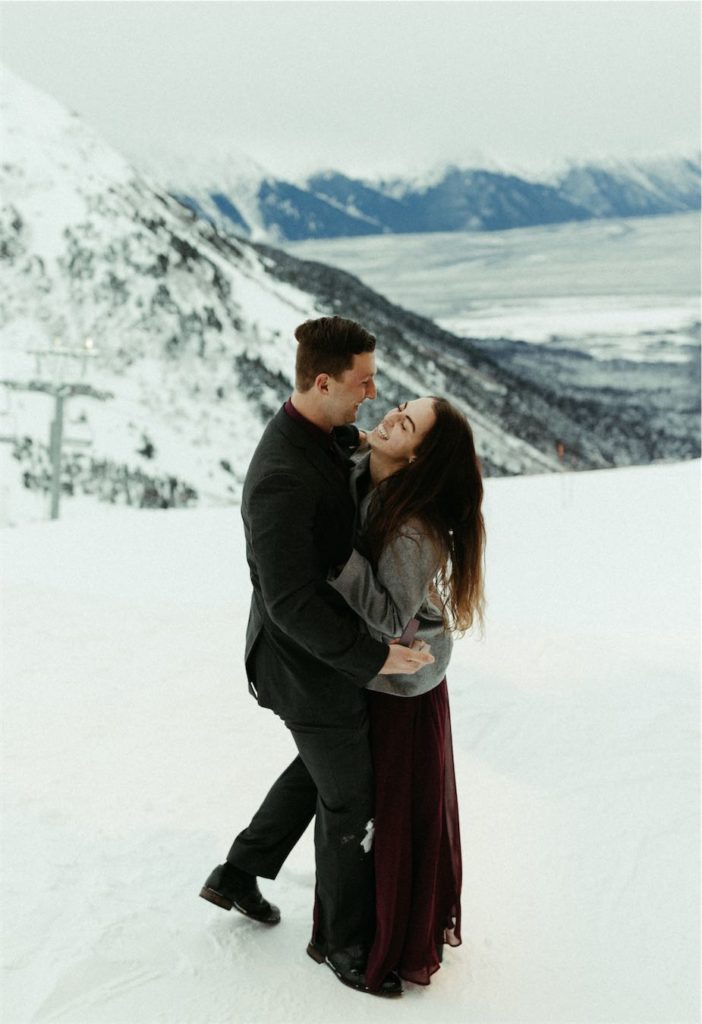 Couple embracing after man asked her to marry him at Alyeska Ski Resort in Girdwood, Alaska