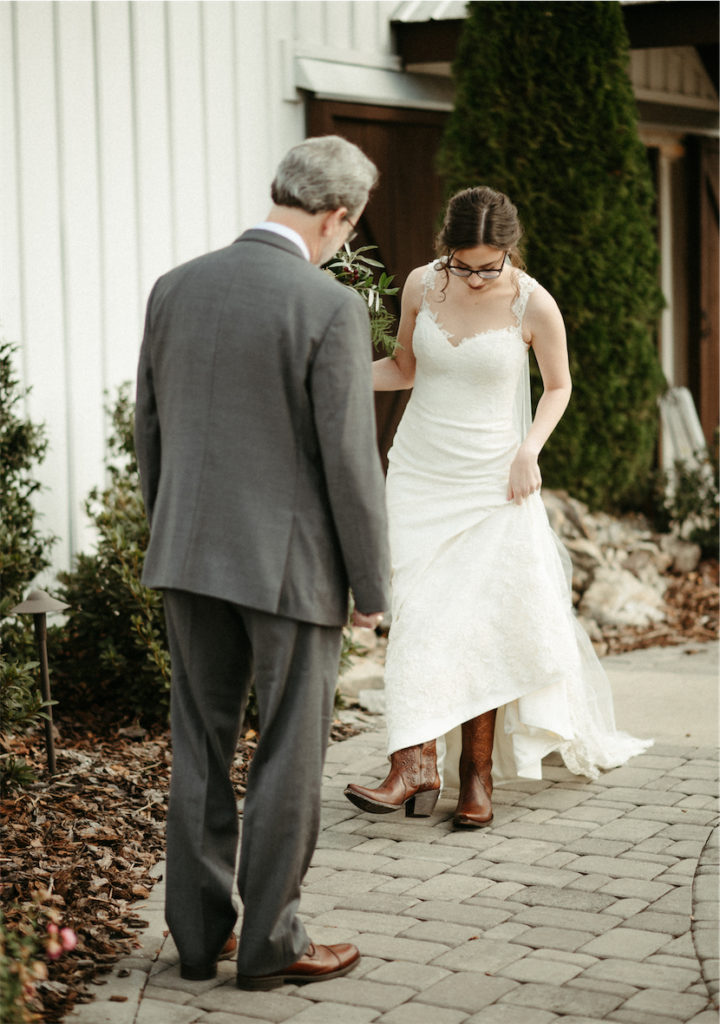 Bride showing her shoes to her dad during her fall wedding 