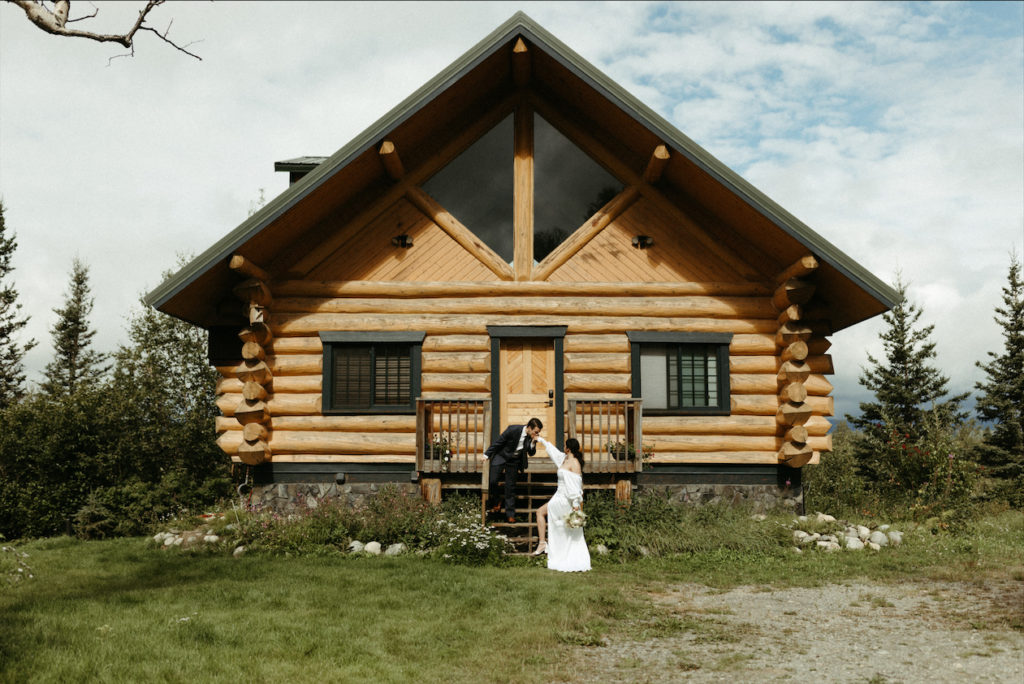 Couple standing in front of their cabin during their Alaska elopement