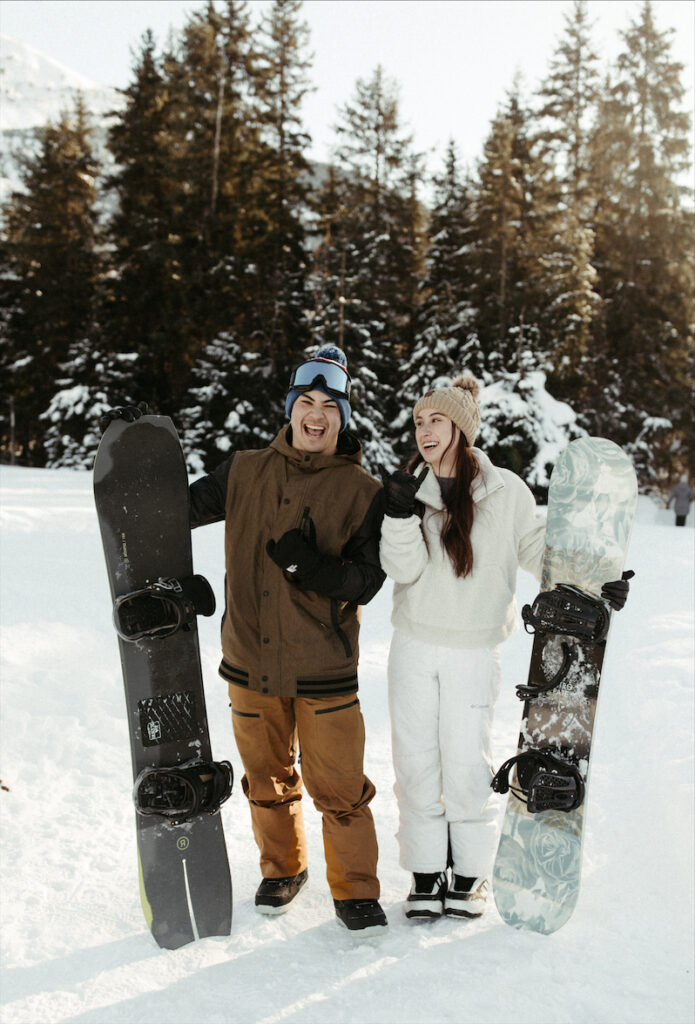 Couple holding onto their snowboards