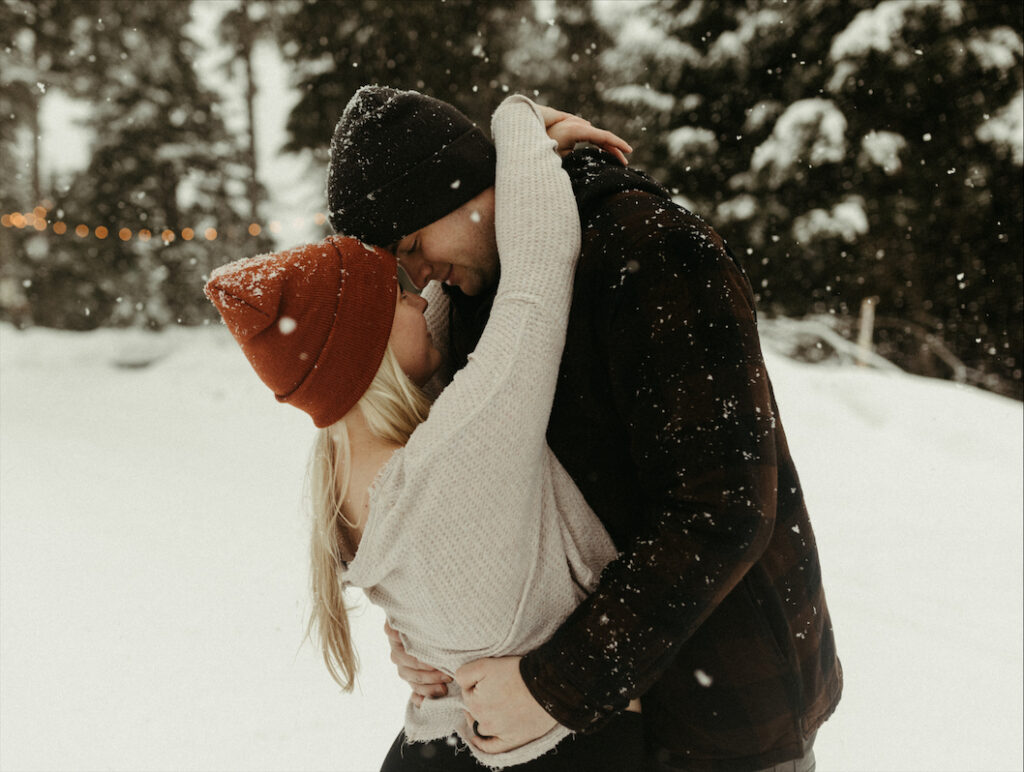 Couple snuggled closed during their winter engagement photos in Girdwood, Alaska