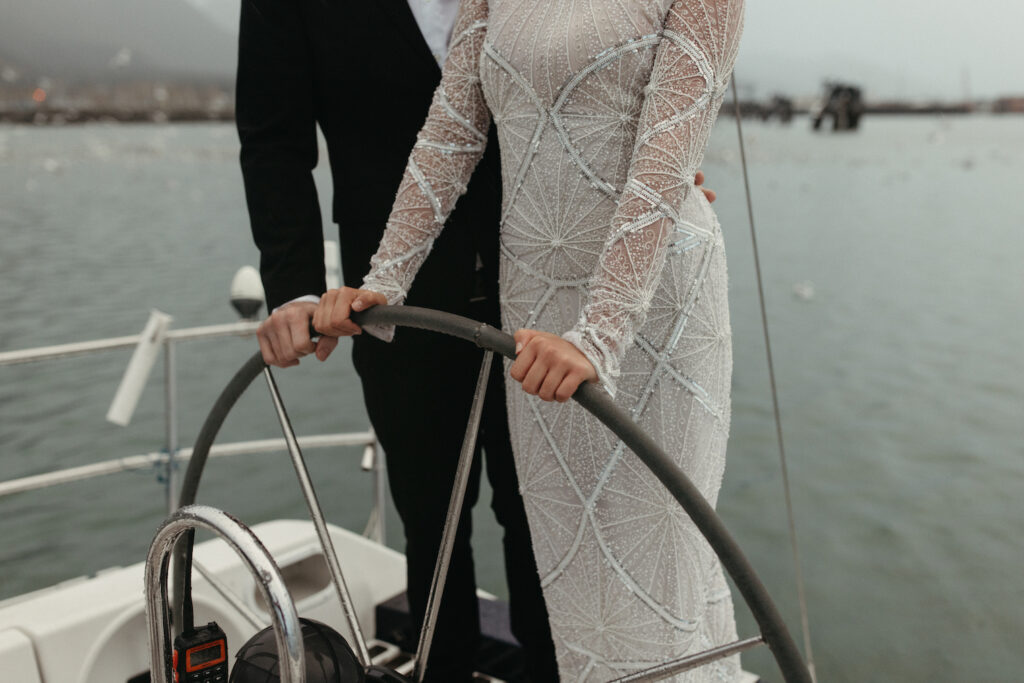 Couple holding the steering wheel of the boat. 