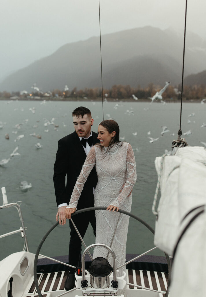 Couple steering the boat to land during their elopement in Seward, Alaska. 