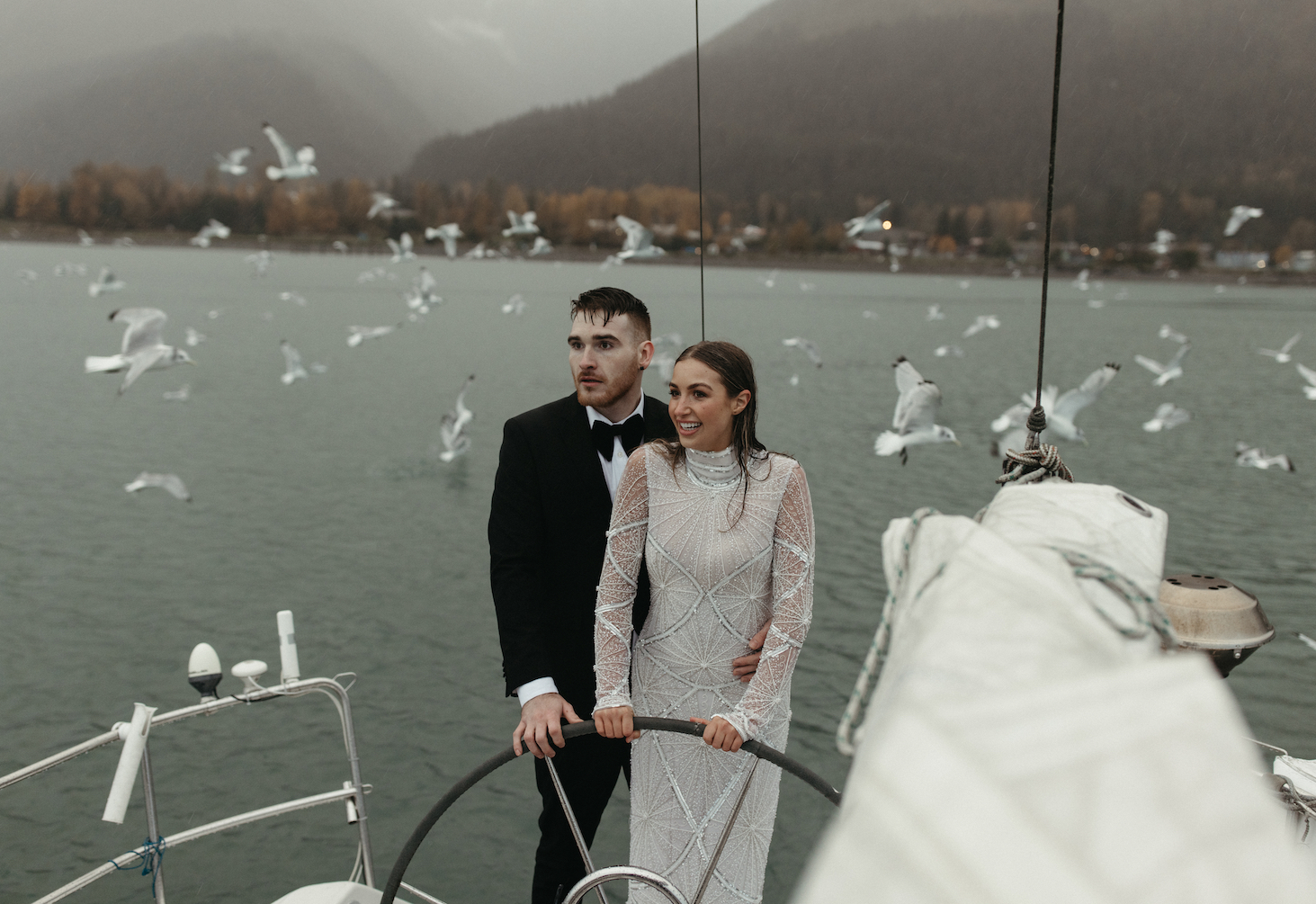 A couple steering a boat during their elopement in Seward, Alaska