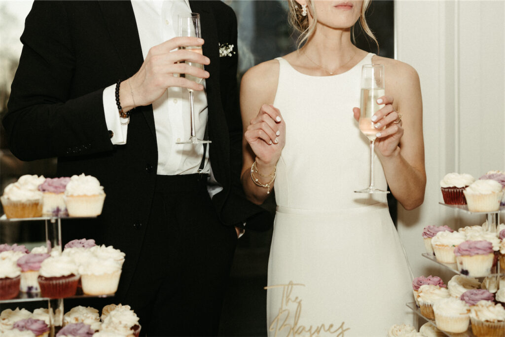 Couple toasting while cutting their wedding cake 
