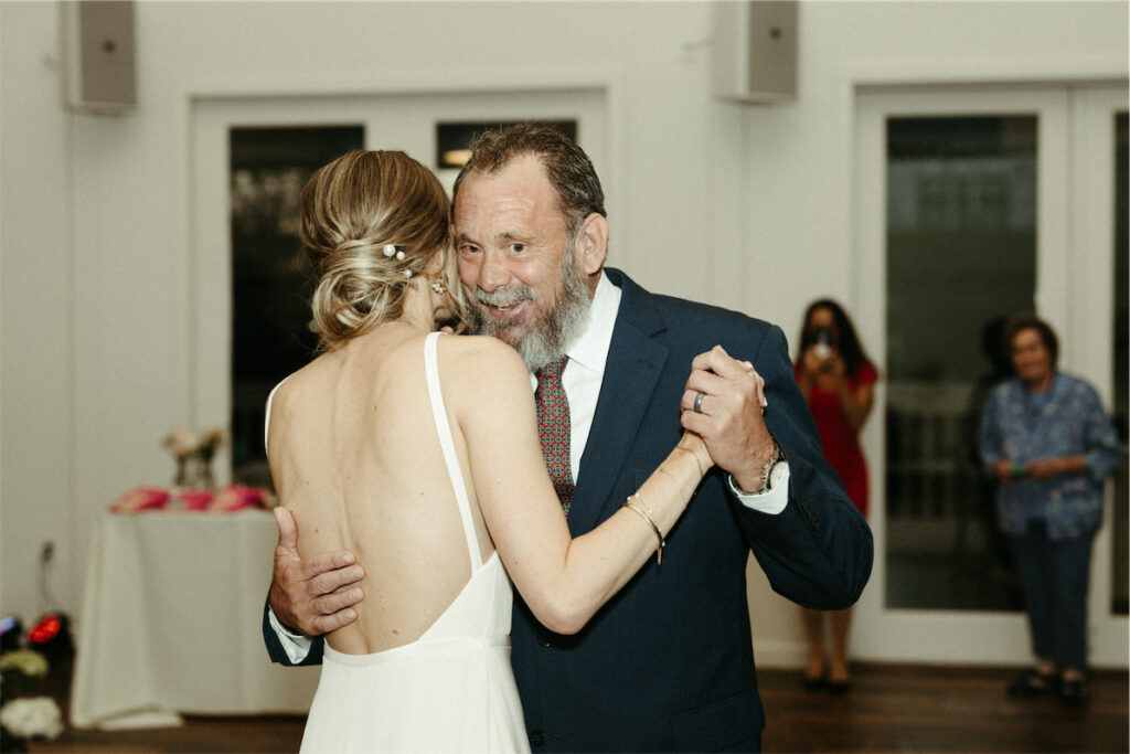 Dad smiling as he dances with his daughter during her spring wedding at The Cordelle
