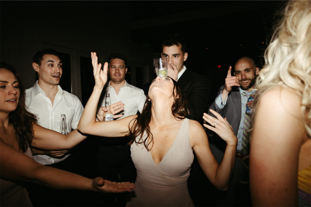 Bridesmaid balancing a drink on her forehead during a reception at The Cordelle 