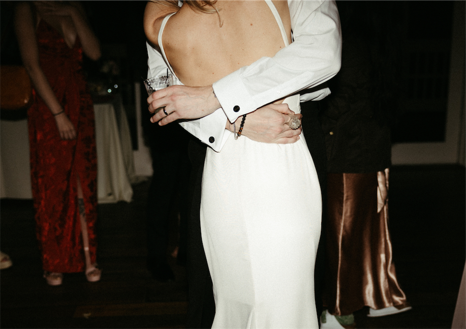 couple snuggled close and dancing out on a dancefloor