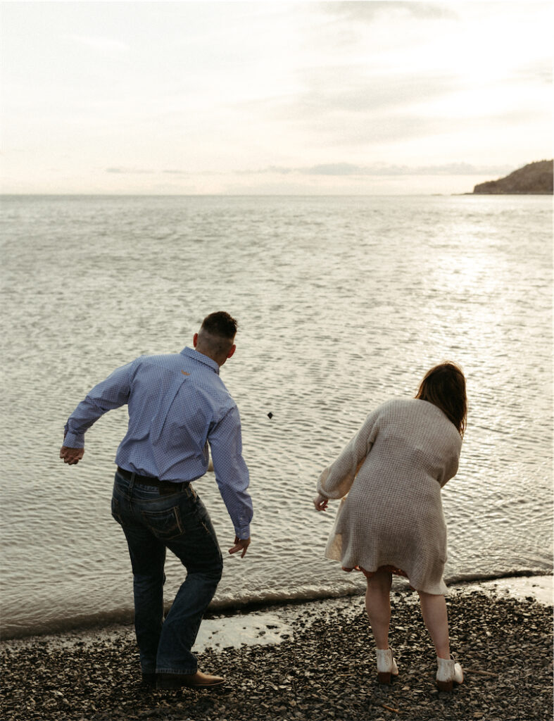 couple skipping rocks during their session at Beluga Point 