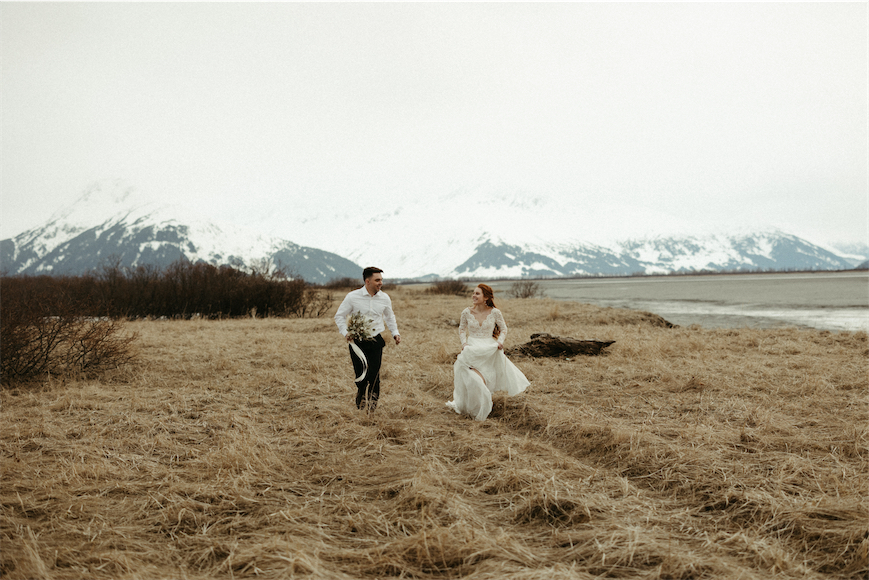 Couple running in the grass during their Girdwood alaska elopement
