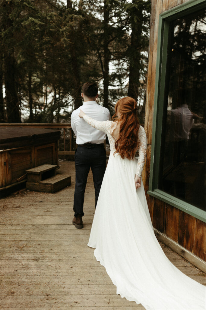 Woman tapping man on shoulder during their elopement first look in Girdwood, Alaska