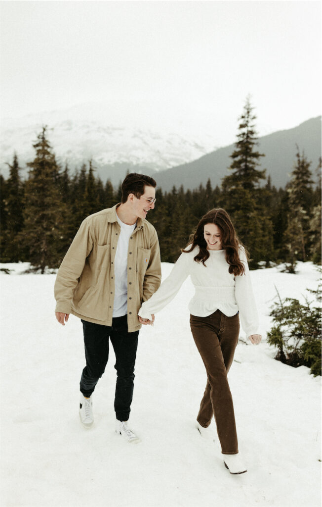 Couple walking and holding hands during their Alaska couples photoshoot