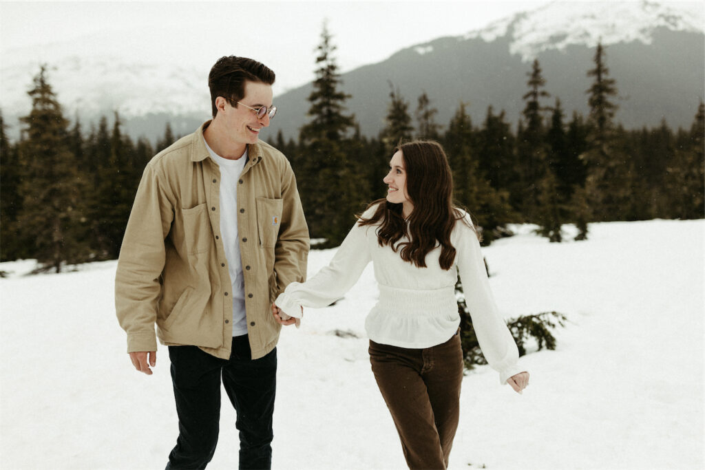 Couple walking in the snow during their spring photo session in Alaska