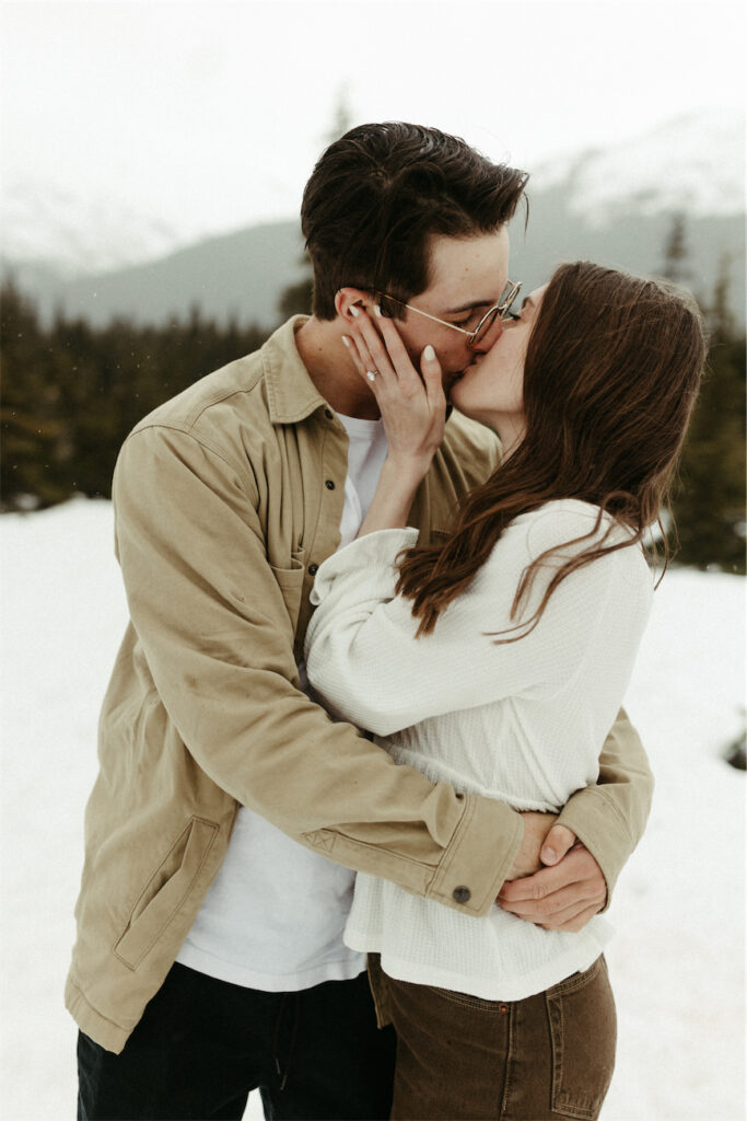 Couple kissing amongst the mountains in Alaska during their engagement session 