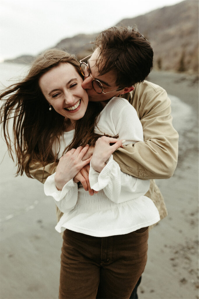 Couple snuggled up close at Beluga Point during their engagement photos