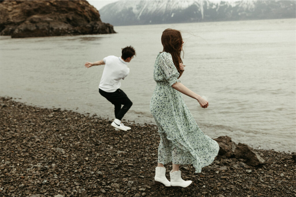 Couple skipping rocks together during their spring engagement session 