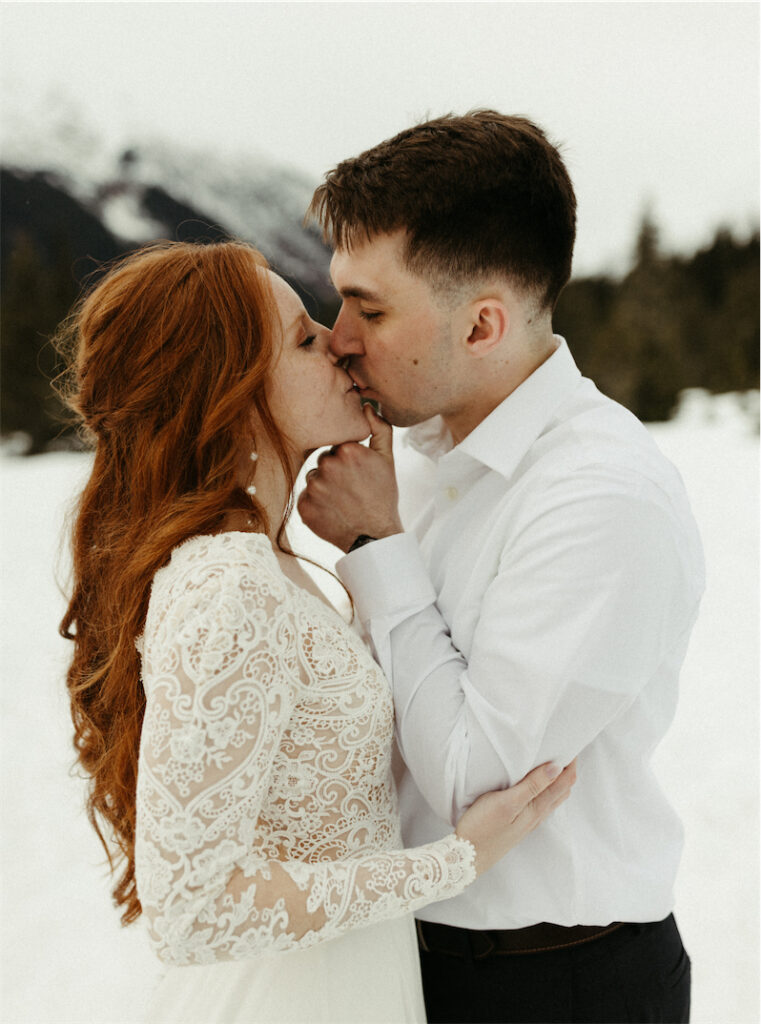 Couple kissing next to the mountains in Girdwood, Alaska during their elopement 