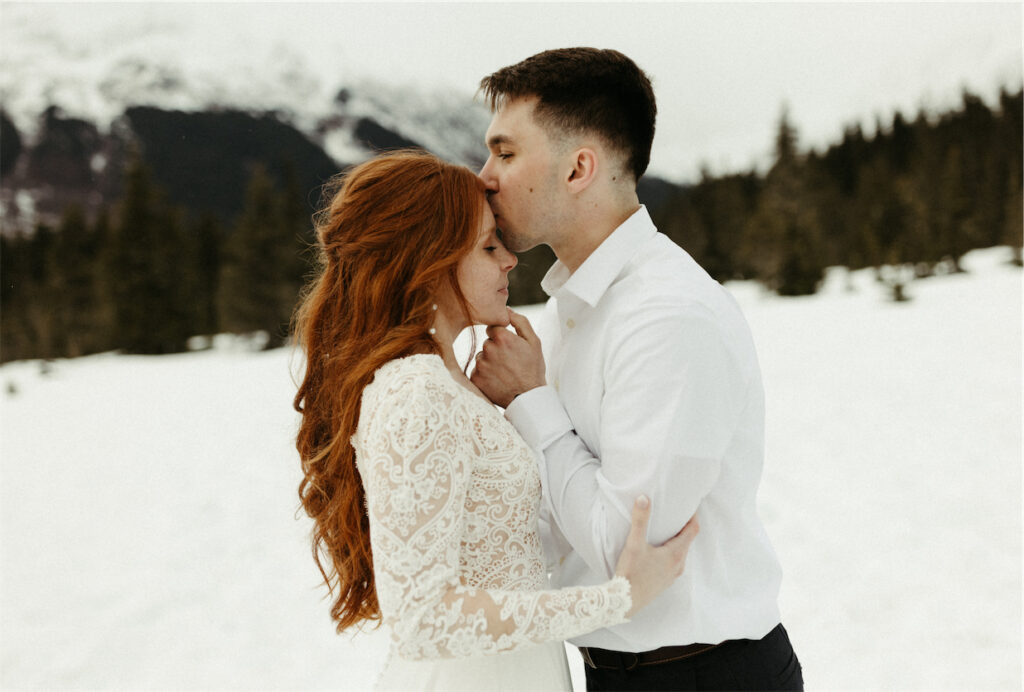 Man kissing woman on the head during their adventure elopement in Girdwood, Alaks 