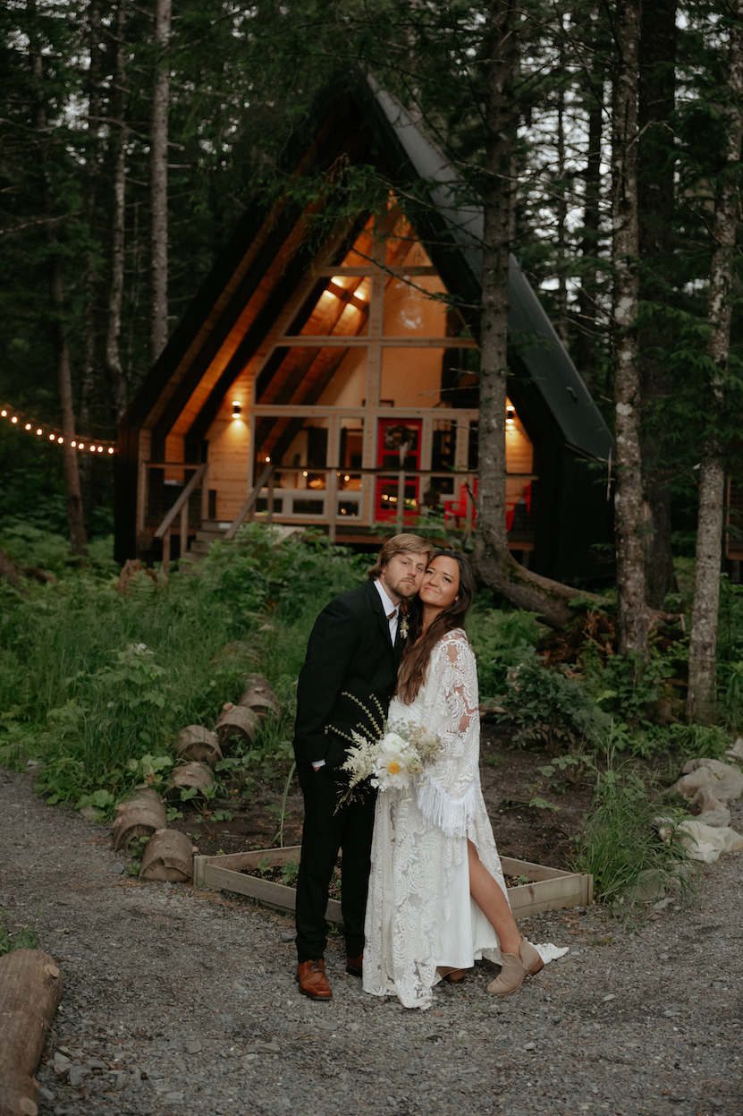 A couple standing next to one another outside Salted Root's, one of the best wedding venues in Alaska. 