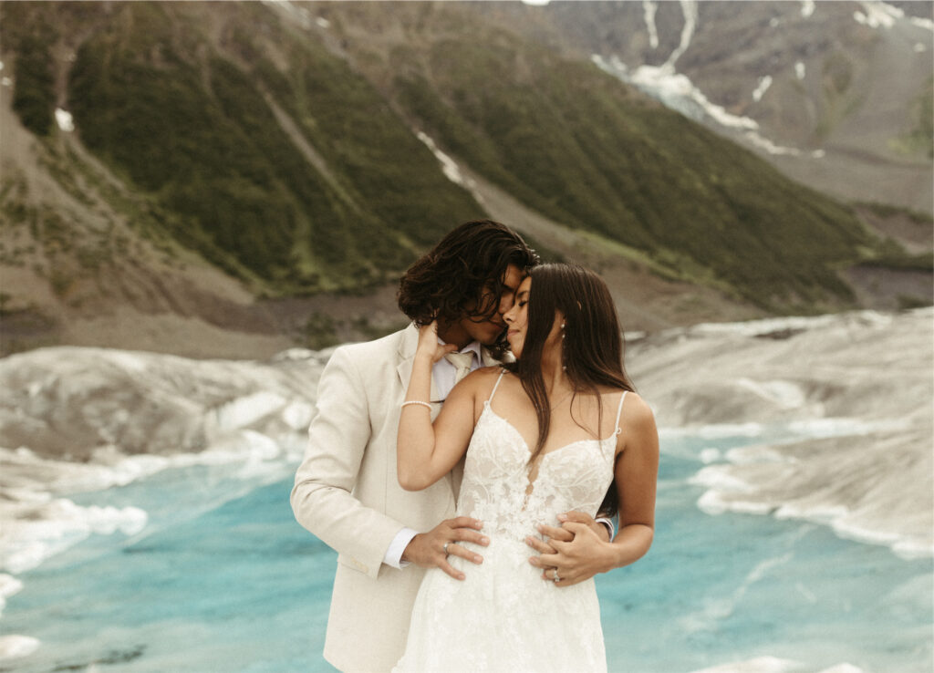 couple snuggled close on a glacier during while eloping in Seward, Alaska