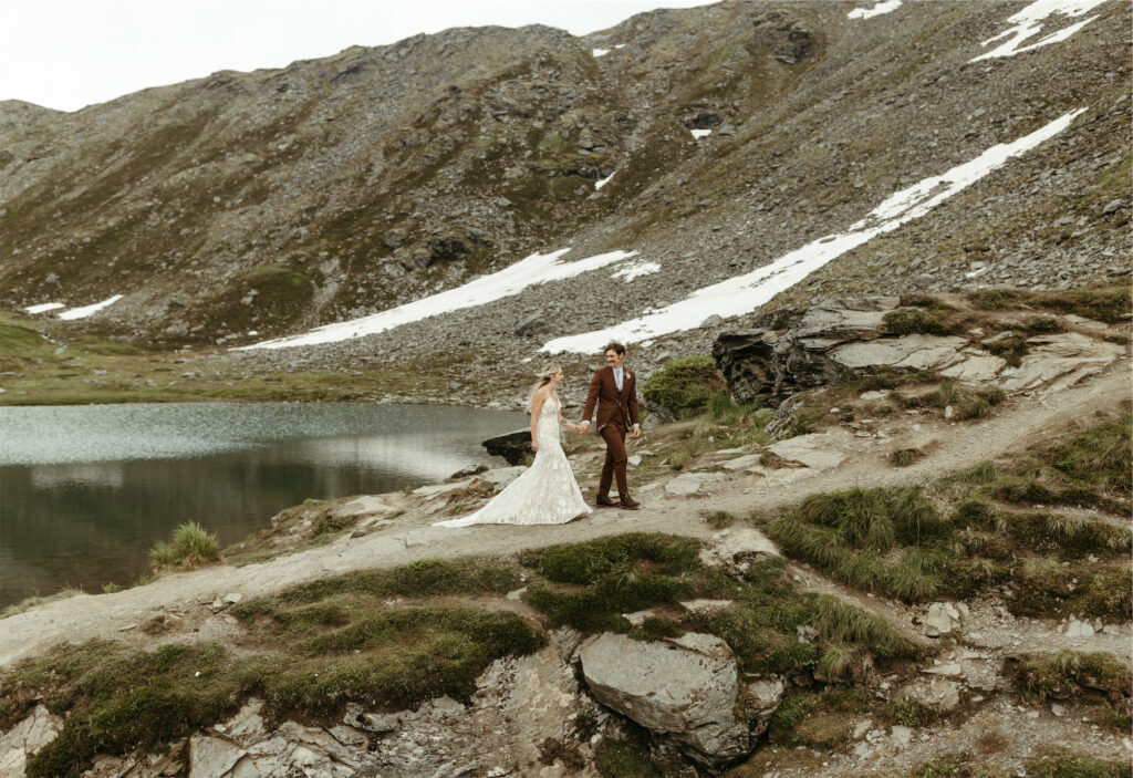 Couple walking near a lake in their wedding attire