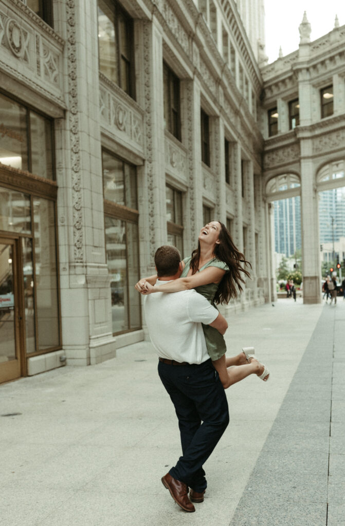 Man picking up woman during engagement photoshoot. 